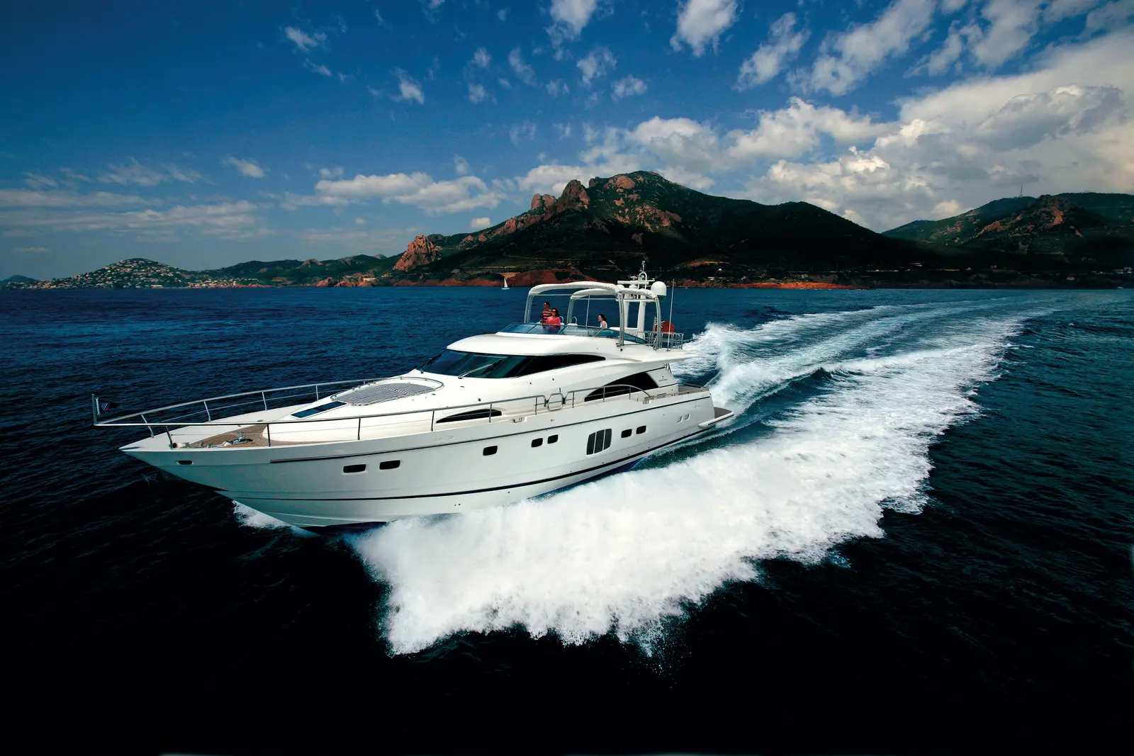 Alacakaranlıkta seyir hâlindeki bir flybridge motoryat
